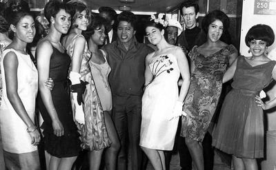 James Brown poses with a large crowd of women.