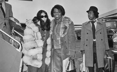 Brown is getting off a plane with his wife Deidre.