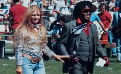 James Brown and Jacqueline Hollander prepare to sing on stage.