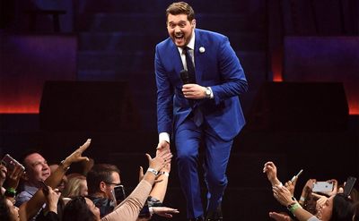 Michael Buble high fives fans as he performs on stage.