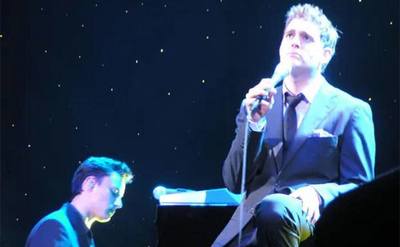 Michael Buble and Alan Chang perform on stage.