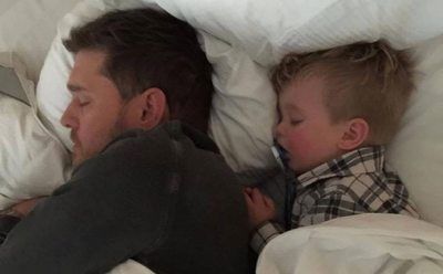 Michael Buble is asleep in bed with his son.