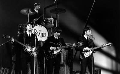 Paul McCartney, Ringo Starr, George Harrison, and John Lennon performing