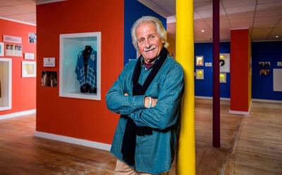 Pete Best standing against a yellow pole in the middle of a room