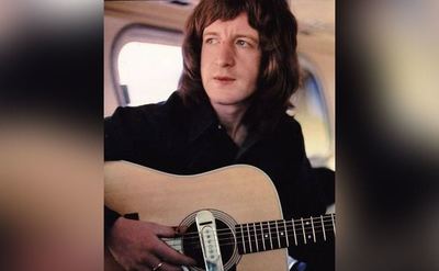 Pete Ham plays his guitar while on the tour bus.