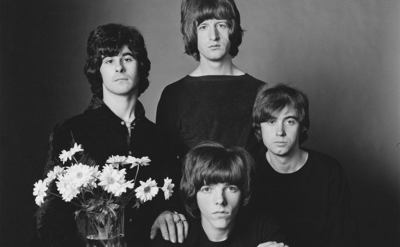Tom Evans, Pete Ham, Mike Gibbins, and Ron Griffiths pose for a studio portrait.
