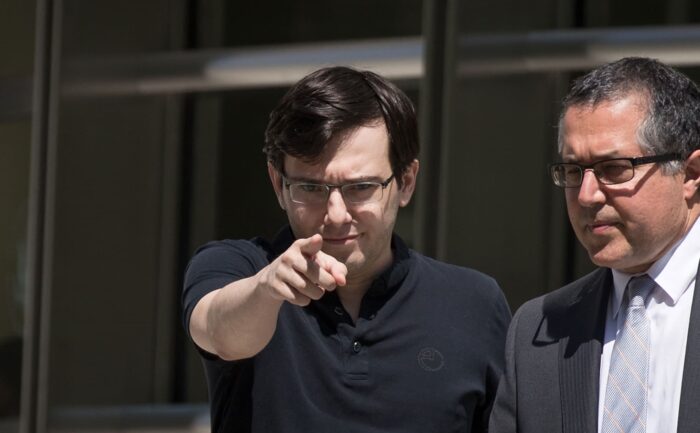 Martin Shkreli points at the press as he exits the courthouse.