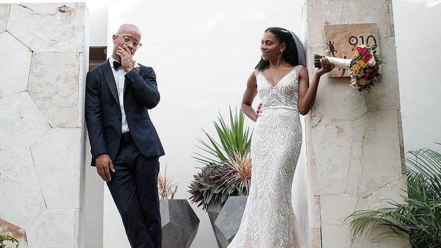 Kelly McCreary and Pete Chatmon posing together in their outfits for the wedding. 