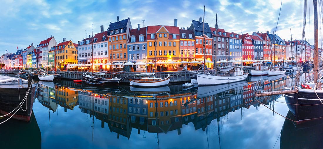 Panorama of the north side of Nyhavn with colorful facades of old houses and old ships in the Old Town of Copenhagen, capital of Denmark