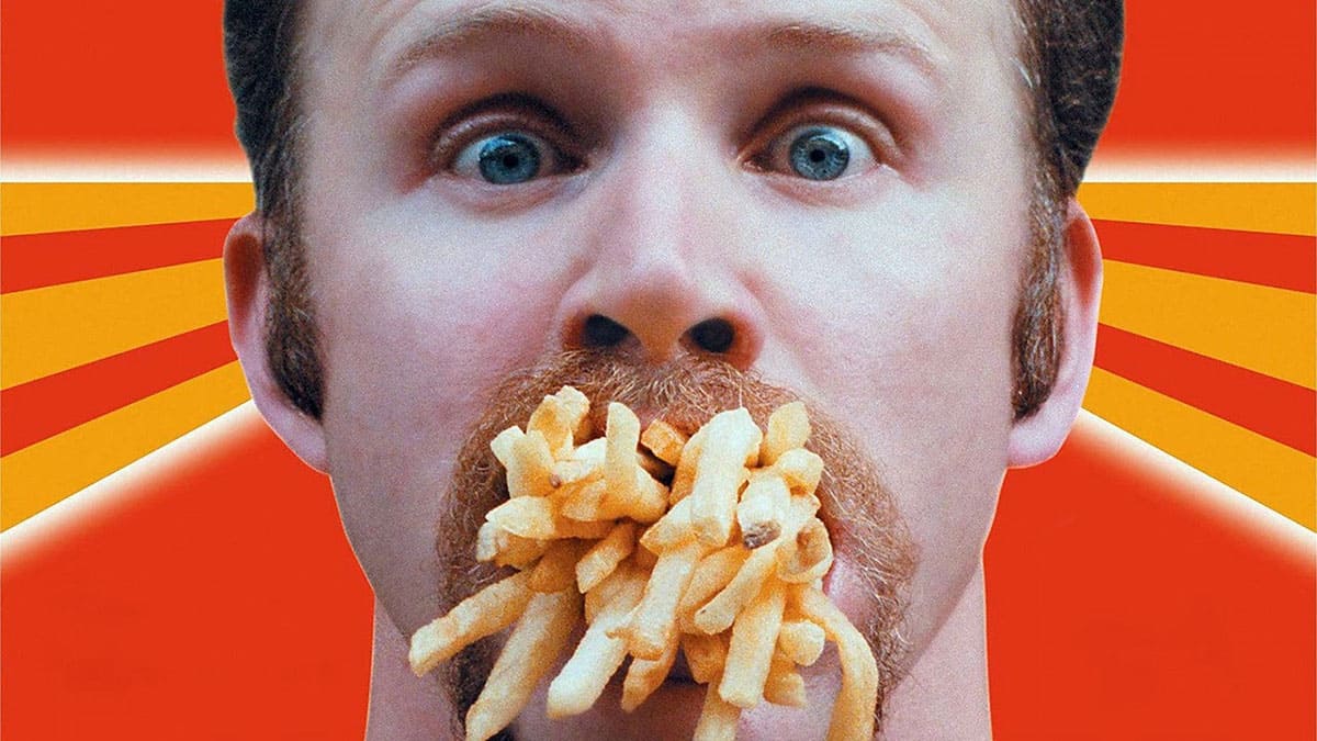 Photo of Morgan Spurlock with a mouth full of McDonald's French fries. 