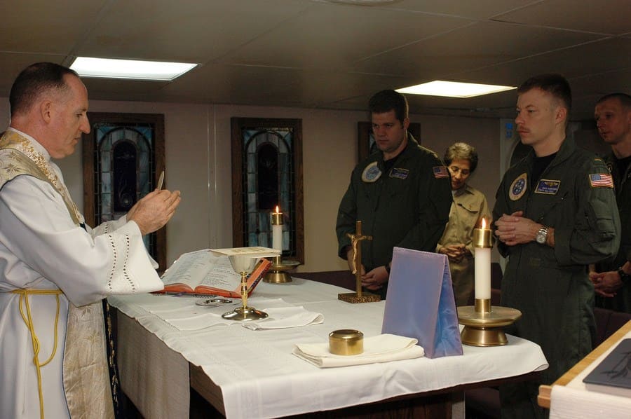 Frank Foley, command chaplain aboard the aircraft carrier USS Nimitz, begins communion during a Roman Catholic Mass.