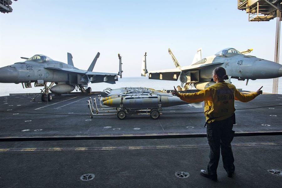 Navy Petty Officer 3rd Class Samantha Finstad acts as the aircraft elevator safety during ordnance transport operations in the hangar bay of the aircraft carrier USS Dwight D. Eisenhower in the Persian Gulf, Oct. 27, 2016.