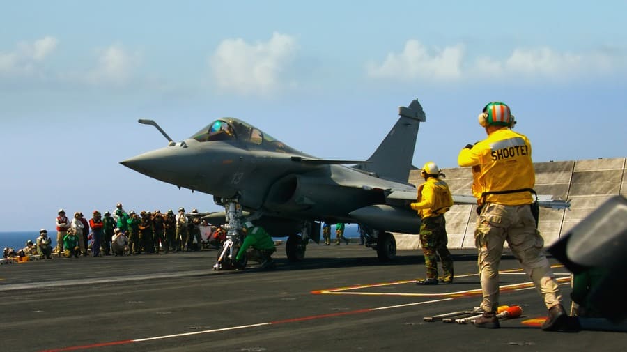 A French rafale fighter prepares to launch from an aircraft carrier in the ocean