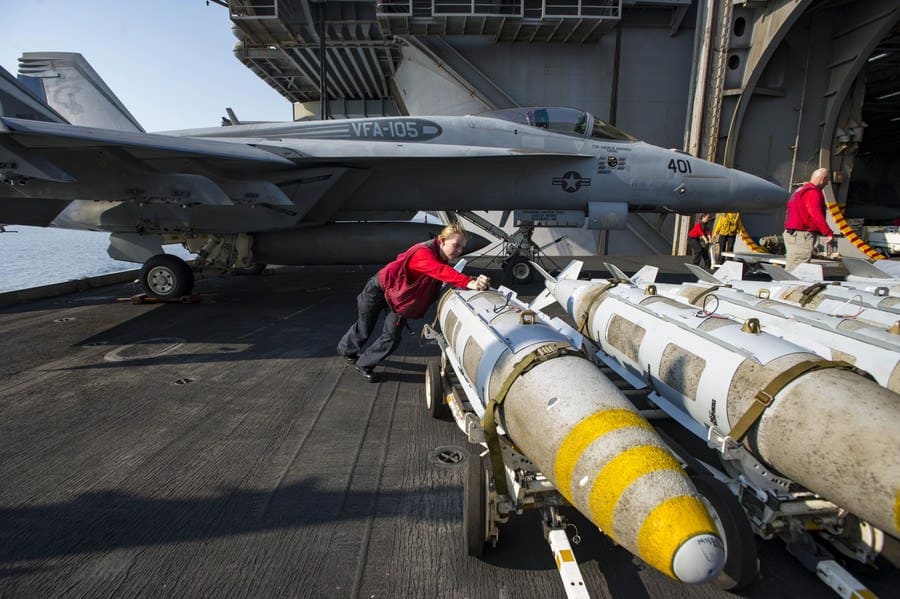 Petty Officer 3rd Class Ashley Wilson, from Macon, Mo., pushes a GBU31 bomb onto an aircraft elevator aboard the aircraft carrier USS Dwight D. Eisenhower