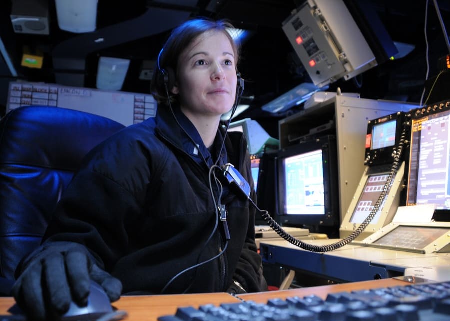 U.S. Navy Lt. j.g. Sara Everett a Combat Direction Center watch officer reviews intelligence slides aboard the aircraft carrier USS Ronald Reagan