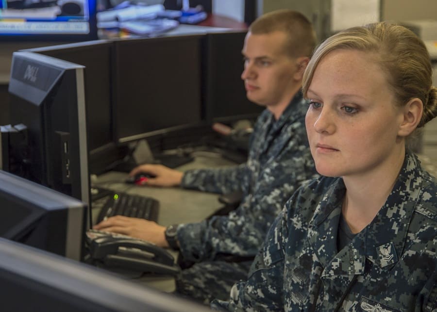 Sitting by computers on an aircraft carrier
