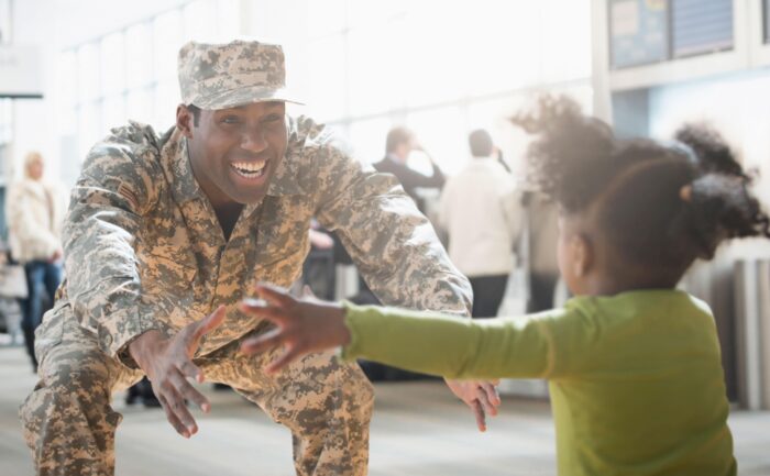 A returning soldier is greeting his daughter.