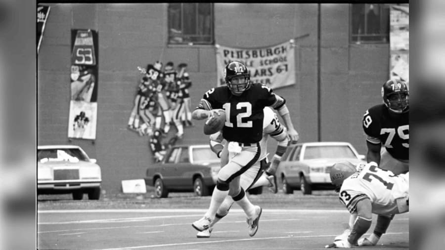 Terry Bradshaw, number 12, running with the football building up his career passing yards. 