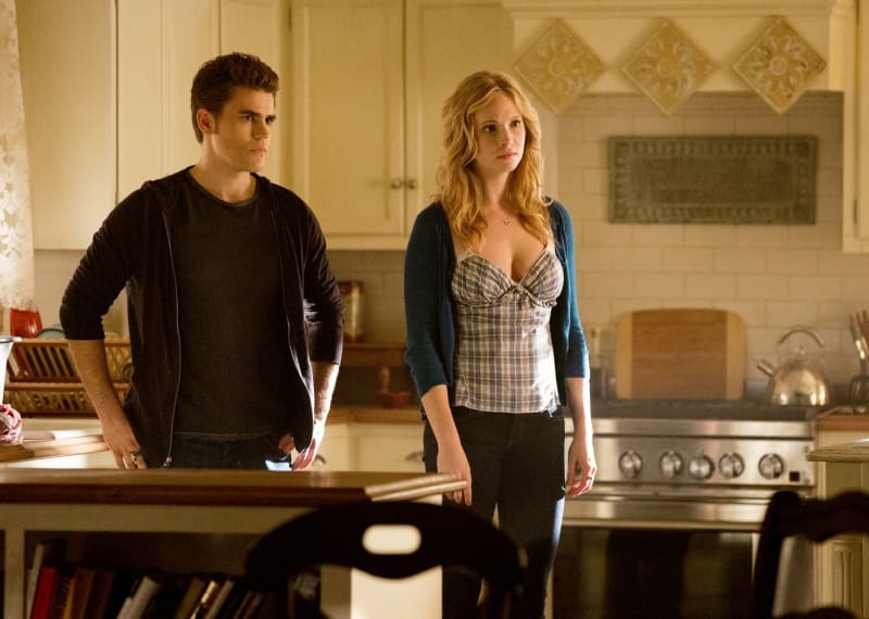Paul Wesley and Candice King are standing in the kitchen in The Vampire Diaries. 