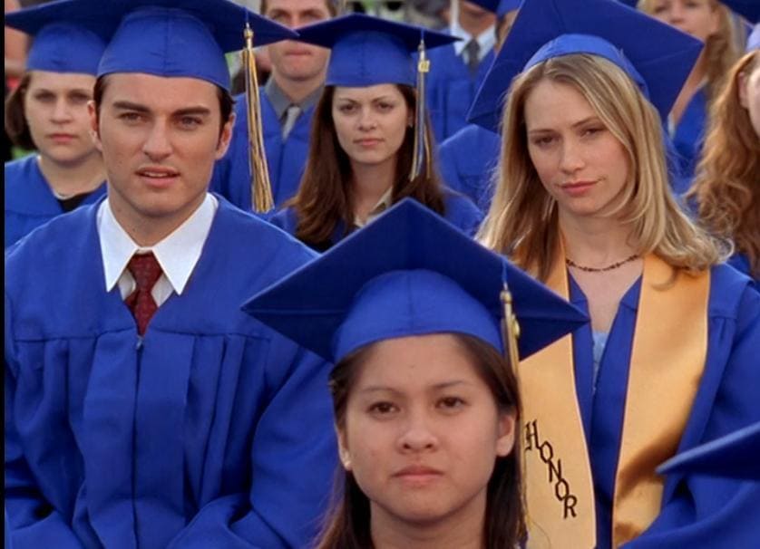Kerr Smith and Meredith Monroe dressed for their graduation in a scene from Dawson’s Creek. 
