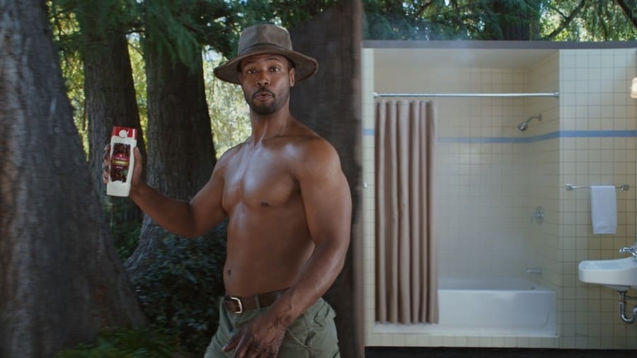 Isaiah Mustafa holding a bottle of Old Spice.