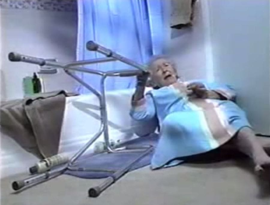 Edith Fore on the floor of the bathroom holding her walker.