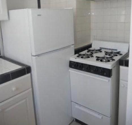 A Stove blocking a fridge from opening-up
