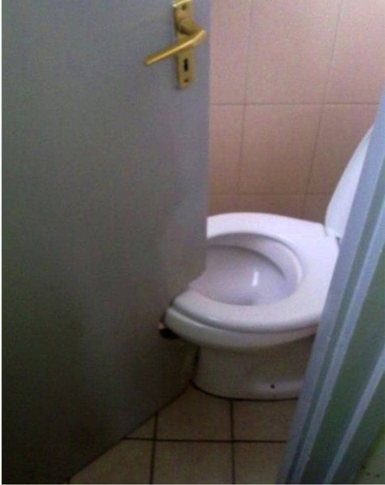 A toilet door cut to enable it to close