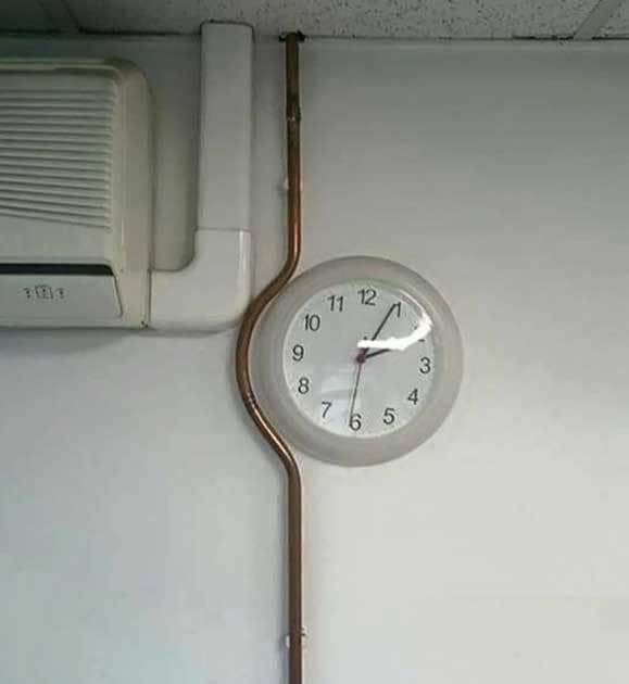 A bent pipe around a wall clock