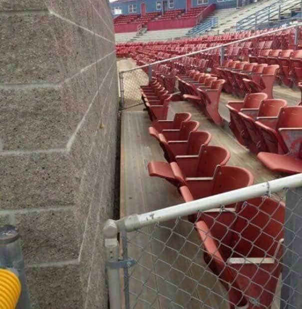 Row of seats in a stadium blocked by a brick wall
