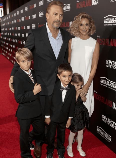 Christine Baumgartner and Kevin Costner posing with their children