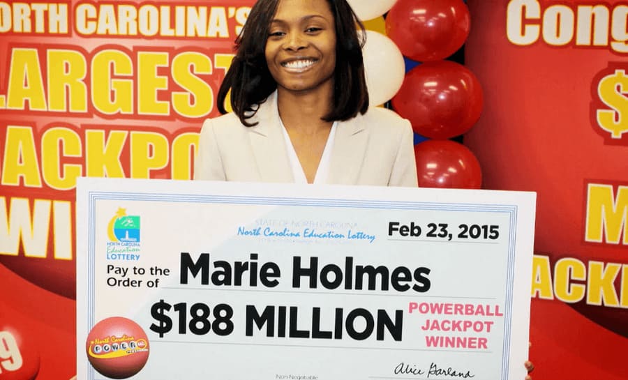 Marie Holmes photographed in front of balloons holding up her check for $188 Million on February 23rd, 2015. 