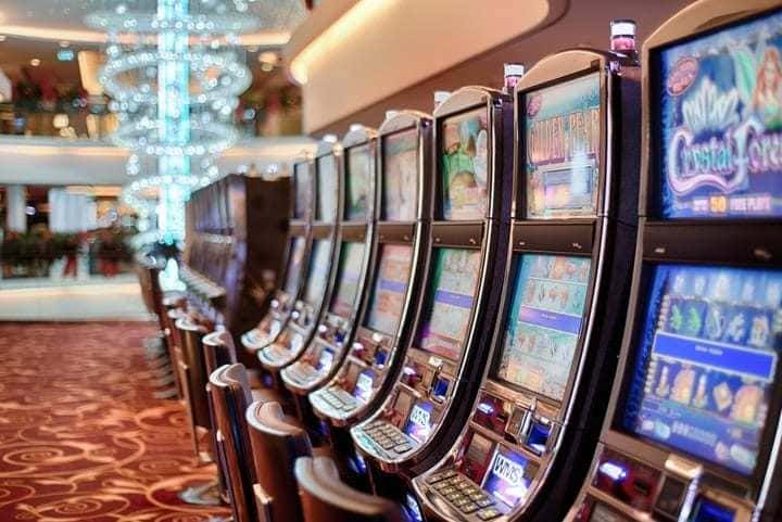 Photograph of slot machines lined up in a nice casino. 