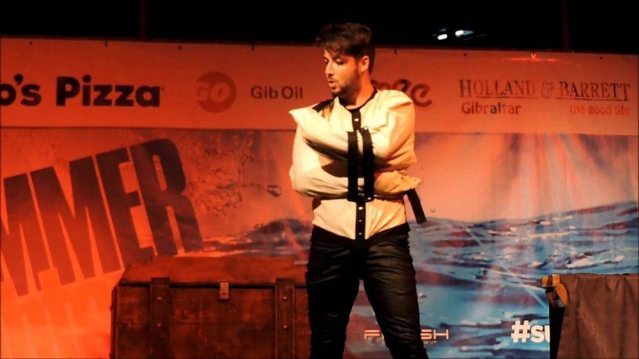 magician on stage in a straitjacket