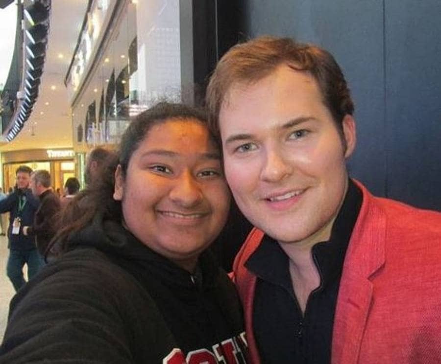 Justin Prentice and Marlen Orozco are posing for a selfie in a shopping center.