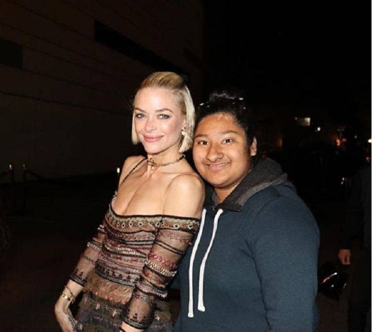 Jaime King and Marlen Orozco are posing outside of an event facing a dark alleyway.