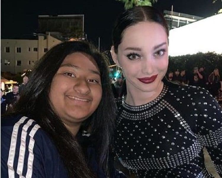 Emma Dumont and Marlen Orozco are posing outside of the Entertainment Weekly red carpet.