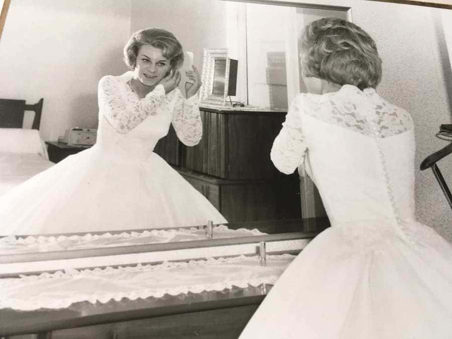 vintage wedding photo of the bride putting on jewelry