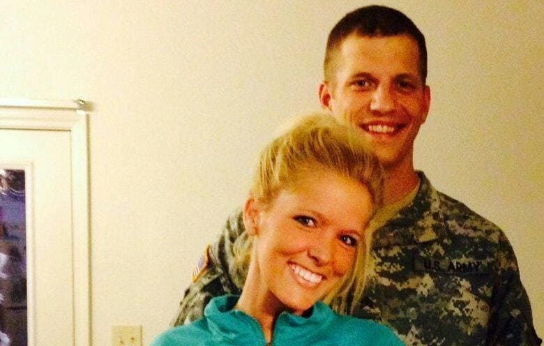Tyler and Mandi Palmer posing in front of a mirror, Tyler in uniform.