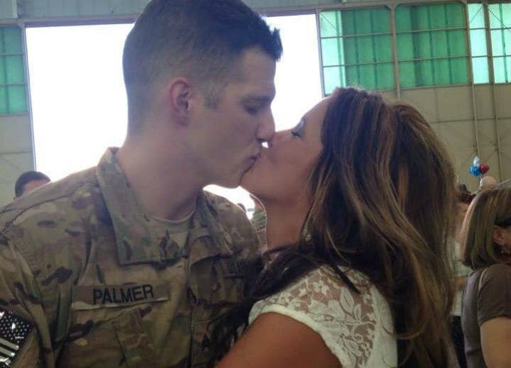 Mandi and Tyler kissing at a military event with Tyler in uniform.