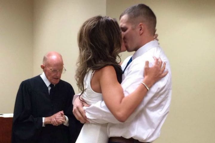 Tyler and Mandi kissing at their wedding ceremony.