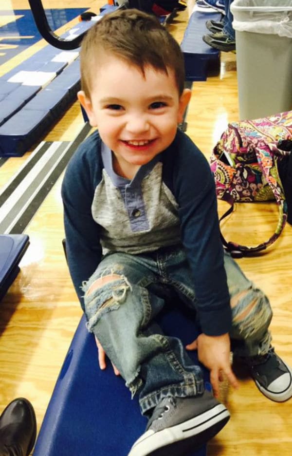 Hunter sitting on a beam smiling.