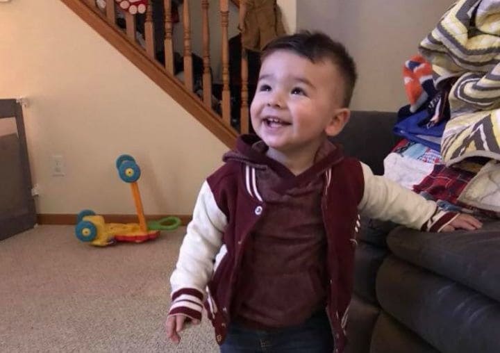 Hunter wearing a bomber jacket leaning against the couch.