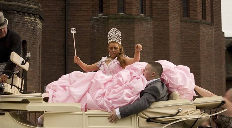 A bride wearing a pink wedding dress with a crown and wand