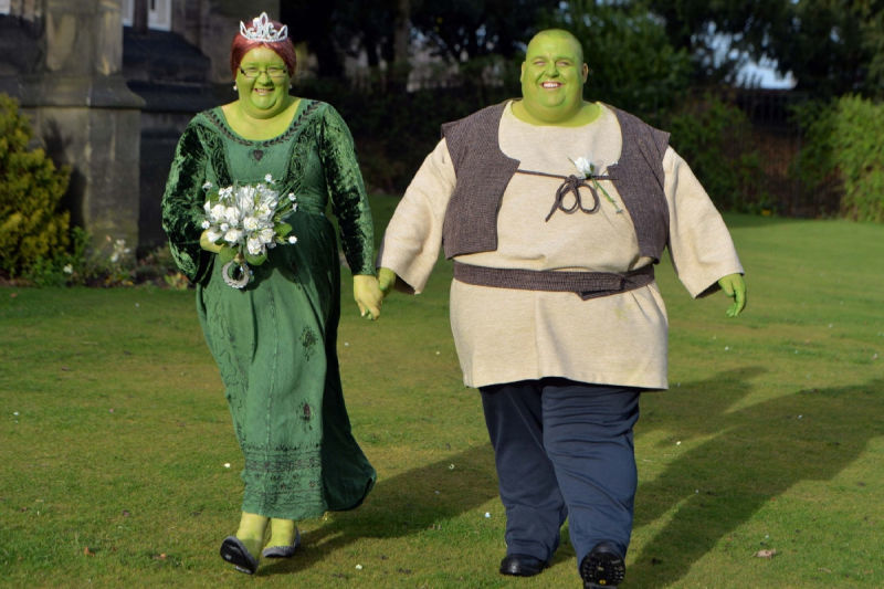 A bride and groom dressed as Shrek and Fiona 