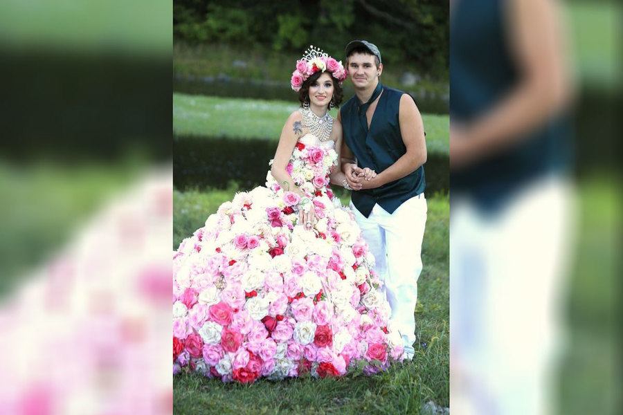 A bride wearing a wedding dress completely covered in flowers 