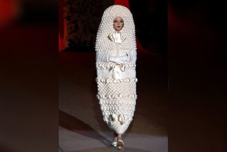 A bride looking like a caterpillar wrapped in a white dress that looks like a blanket