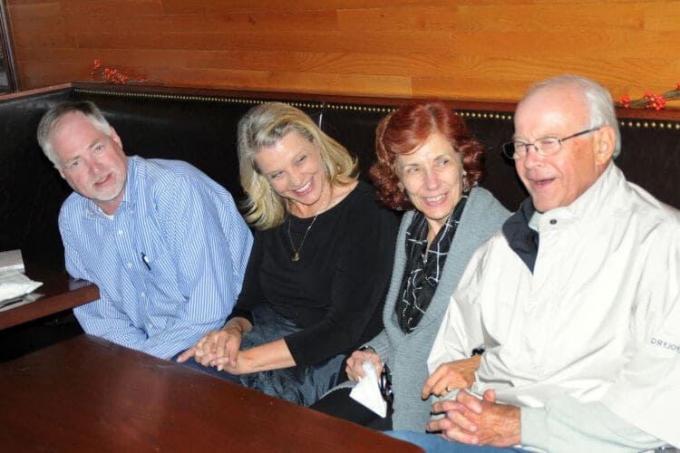Karen, Denis, Jean, and her husband sitting at a booth in a restaurant.