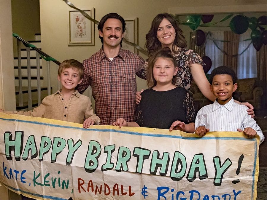 Jack, Rebecca, Randall, Kate, and Kevin holding a large sign for all of their birthdays.