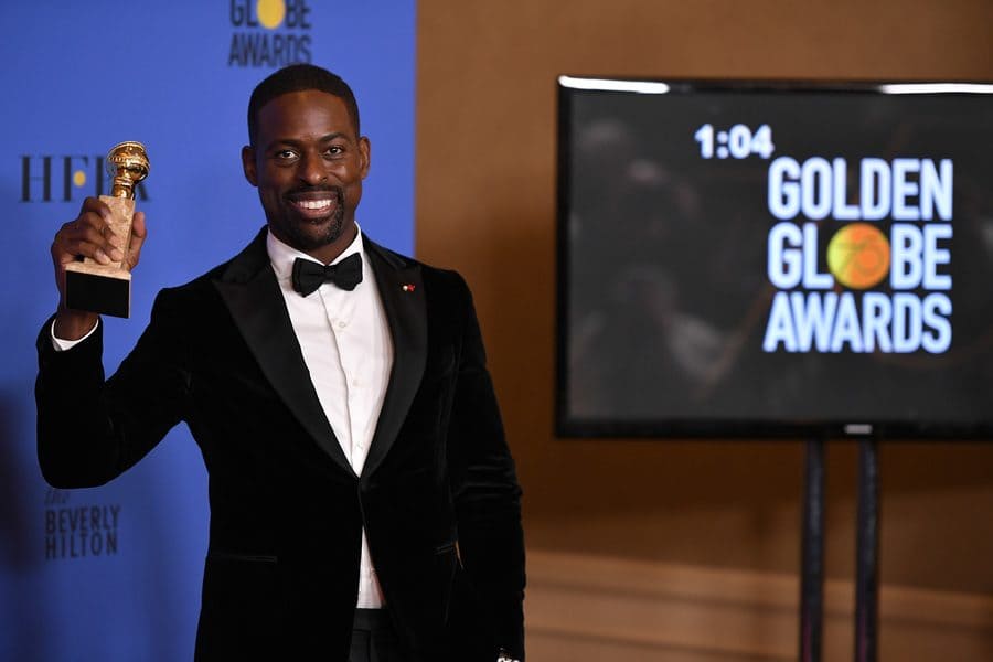 Sterling K. Brown holding up his Golden Globe at the Golden Globe Awards in 2018.